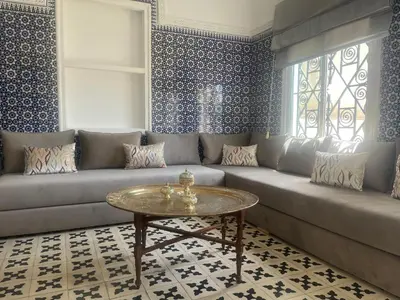 a living room with a couch and a table at Maison traditionnelle spacieuse in Rabat