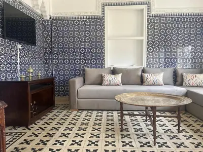 a living room with a couch and a table at Maison traditionnelle spacieuse in Rabat