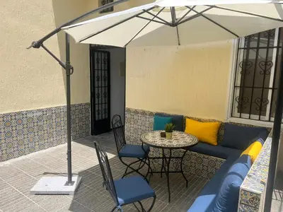 a patio with a table and chairs and an umbrella at Maison traditionnelle spacieuse in Rabat