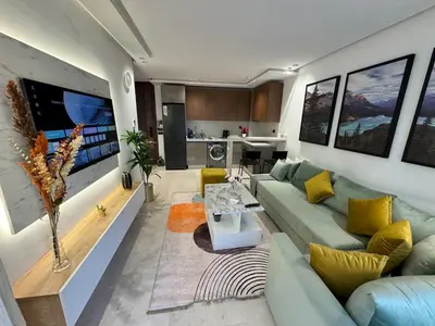 a living room with a blue couch and yellow pillows at Escale Confortable pour un Séjour Inoubliable in Maarif