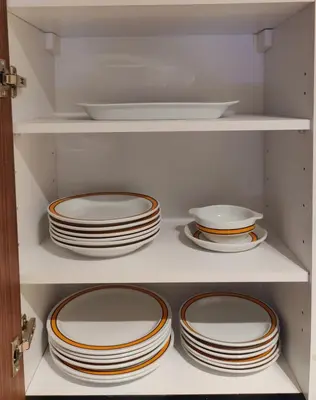 a white cabinet filled with plates and bowls at HSuites Casablanca, Suite H Prime, Elegant one bedroom apartment in Casablanca