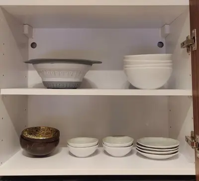 a shelf with bowls and other dishes on it at HSuites Casablanca, Suite H Prime, Elegant one bedroom apartment in Casablanca