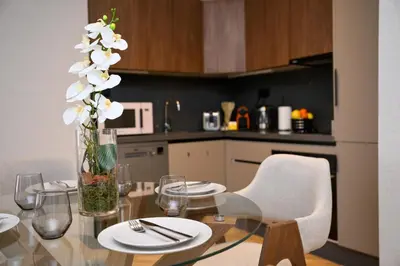 a kitchen with a glass table with a vase of flowers at HSuites Casablanca, Suite H Prime, Elegant one bedroom apartment in Casablanca