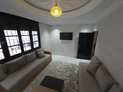 a living room with a couch and a tv at Faridi house in Casablanca