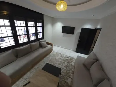 a living room with a couch and two windows at Faridi house in Casablanca