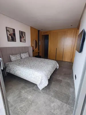 a bedroom with a large bed and wooden cabinets at Panoramic ocean view appartement in Casablanca