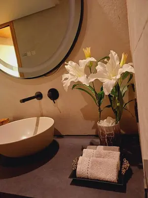 a bathroom with a sink and a vase with white flowers at Panoramic ocean view appartement in Casablanca