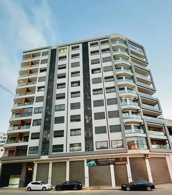 a large building with cars parked in front of it at Apartment with GYM ! Private parking in Casablanca