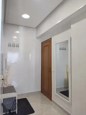a hallway with a wooden door in a white room at Wafa in Casablanca