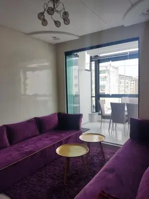 a living room with a purple couch and two tables at Wafa in Casablanca