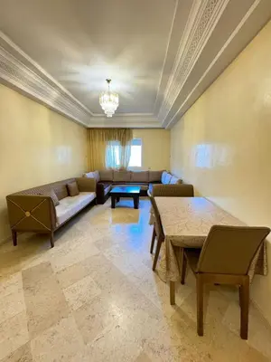 a living room with a couch and a table at Jardin mohammedia in Mohammedia