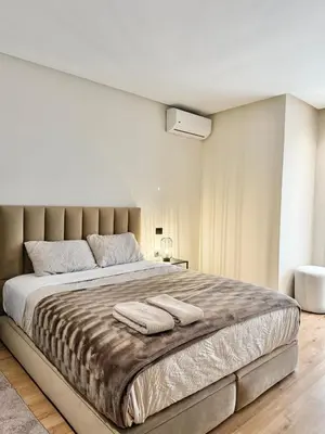a bedroom with a large bed with two towels on it at Appartement Oasis in Casablanca