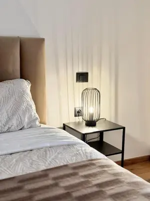 a bedroom with a bed and a table with a lamp at Appartement Oasis in Casablanca
