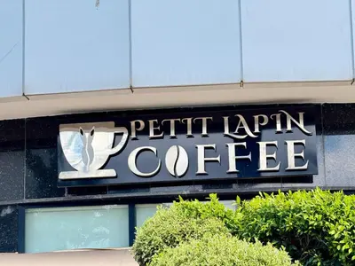 a sign on the side of a pitt farm coffee building at Appartement Sacré-Cœur in Casablanca