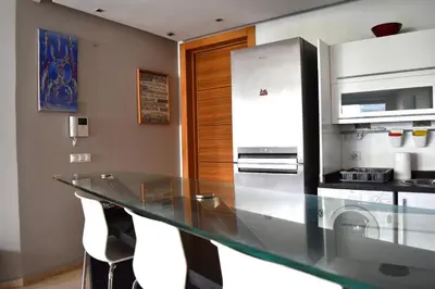 a kitchen with a glass counter and a refrigerator at Appartement Sacré-Cœur in Casablanca