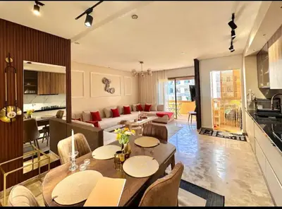a kitchen and a living room with a table and chairs at Kawtar in Mansouria