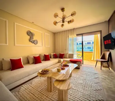 a living room with a couch and a table at Kawtar in Mansouria
