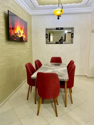 a dining room with a table and red chairs at casa bella in Casablanca