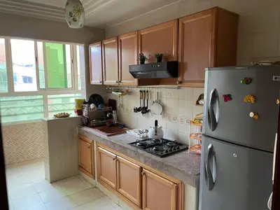 a kitchen with wooden cabinets and a refrigerator at Dar dyafa in Casablanca