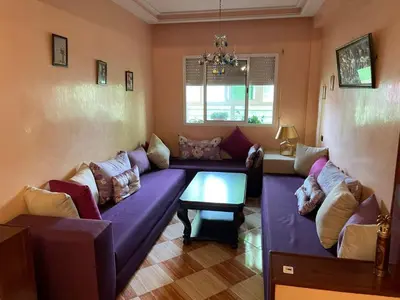 a living room with a purple couch and a table at Dar dyafa in Casablanca