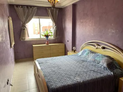 a bedroom with a bed with purple walls and a window at Dar dyafa in Casablanca