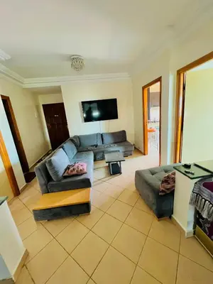 a living room with a couch and a tv at Apparemment à louer au centre ville Bouznika in Bouznika