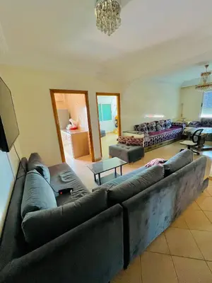 a living room with a large couch in a room at Apparemment à louer au centre ville Bouznika in Bouznika