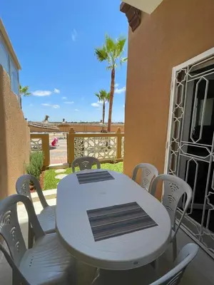 a white table and chairs on a balcony with palm trees at Kawtar in Pont Blondin