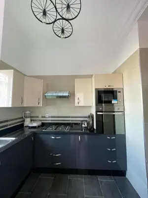 a kitchen with black and white appliances and a chandelier at Kawtar in Pont Blondin