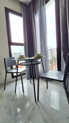 a table and chairs in a room with a balcony at Modern apartment in Casablanca in Casablanca
