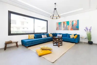 a living room with a blue couch and a table at Beach Vibe Villa - Sunny Stay in O Ben Slimane