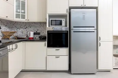 a refrigerator in a kitchen with white cabinets at Beach Vibe Villa - Sunny Stay in O Ben Slimane