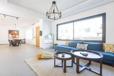 a living room with a blue couch and a table at Beach Vibe Villa - Sunny Stay in O Ben Slimane