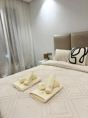 a white bed with two towels on top of it at Beautiful spacious apartment in Casablanca in Casablanca