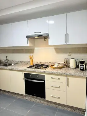 a kitchen with white cabinets and a black stove top oven at Beautiful spacious apartment in Casablanca in Casablanca