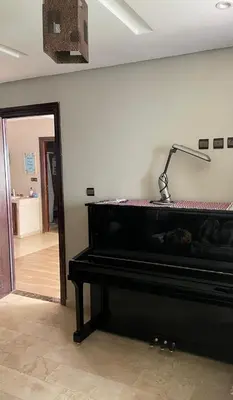 a black piano sitting in a room with a hallway at Chambres Surf,Piano et Arts in Tamaris