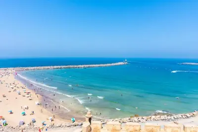 a beach with a group of people in the water at La passage inoubliable F in Bouznika