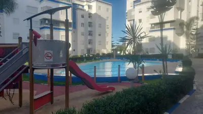 a girl on a slide by a swimming pool at La passage inoubliable F in Bouznika
