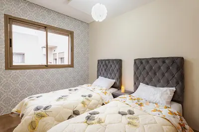 two beds sitting next to each other in a bedroom at Appartement au parc à 3 minutes de la plage in Mohammedia