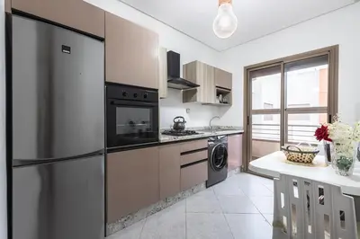a kitchen with a refrigerator and a dishwasher at Appartement au parc à 3 minutes de la plage in Mohammedia