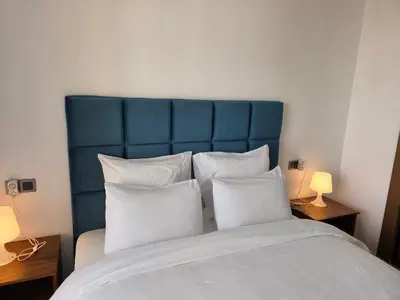a bed with a blue headboard and white pillows at Résidence EDEN 4 - Casablanca Center in Casablanca