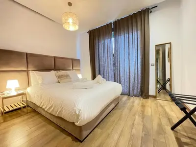 a bedroom with a large bed and a large window at Cozy Boho 2BR Prestigia Stadium View in Rabat