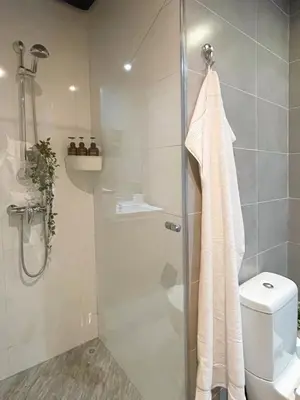 a bathroom with a shower and a toilet at Cozy Boho 2BR Prestigia Stadium View in Rabat