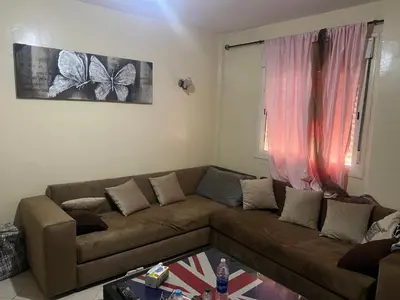 a living room with a brown couch and a window at Appartement farah salam oulfa in Casablanca
