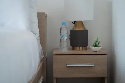 a bottle of water on a night stand next to a bed at Studio Raffiné et Lumineux in Casablanca