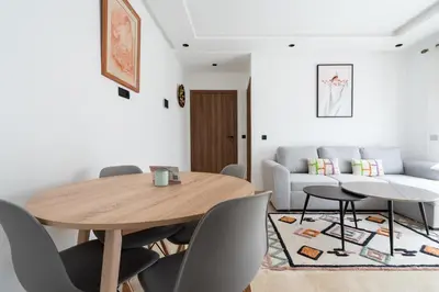 a living room with a wooden table and chairs at Studio Raffiné et Lumineux in Casablanca
