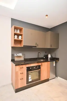 a kitchen with wooden cabinets and a counter top at Atelier Aedes - Studio 2 in Maarif
