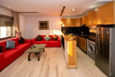 a living room with a red couch and a kitchen at 1BR - Casa Voyageurs - Belvedere in Maarif