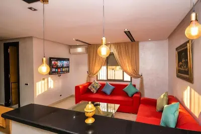 a living room with a red couch and a red chair at 1BR - Casa Voyageurs - Belvedere in Maarif