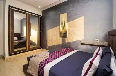 a bedroom with a bed and a large mirror at 1BR - Casa Voyageurs - Belvedere in Maarif
